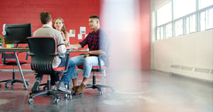 Unposed group of creative business people in an open concept office brainstorming their next project.